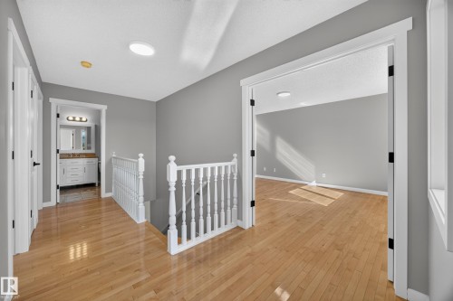 Hardwood flooring throughout, white trim and doors, contemporary gray wall tones, recessed lighting, and a white vanity with a rectangular sink - 3640 31 Street Nw, Edmonton, AB - Indoor Photo Showing Other Room