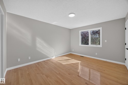 Wood-finish flooring, white trim, and a window with white casing - 3640 31 Street Nw, Edmonton, AB - Indoor Photo Showing Other Room
