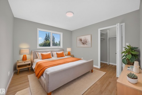 Hardwood-style flooring, light gray wall tones, ceiling-mounted light fixture, double-pane window, and a bi-fold closet - 3640 31 Street Nw, Edmonton, AB - Indoor Photo Showing Bedroom