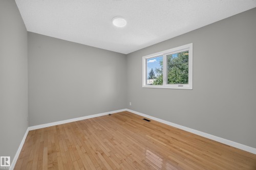 Bedroom 4.  Hardwood-finish flooring, neutral gray wall tones, and white trim - 3640 31 Street Nw, Edmonton, AB - Indoor Photo Showing Other Room
