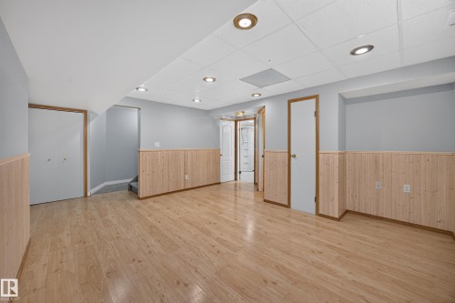 Wood-finish flooring, light wood paneling, recessed ceiling lighting, drop ceiling, and light gray wall paint - 3640 31 Street Nw, Edmonton, AB - Indoor Photo Showing Other Room