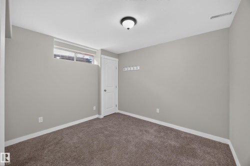 Bedroom 6.  Neutral gray walls, dark brown carpet, white trim, frosted glass window, and a white interior door - 3640 31 Street Nw, Edmonton, AB - Indoor Photo Showing Other Room