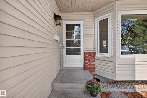 Cream-colored siding exterior with a white full-light entry door - 3640 31 Street Nw, Edmonton, AB - Outdoor With Exterior