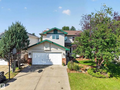 Two-story residence featuring light-colored siding, a prominent two-car garage, and a concrete driveway - 3640 31 Street Nw, Edmonton, AB - Outdoor