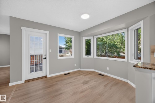 Recessed lighting, wood-finish flooring, bay window, light gray wall finishes, and a glass-paneled door - 3640 31 Street Nw, Edmonton, AB - Indoor Photo Showing Other Room