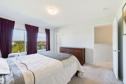 Expansive windows, light neutral wall tones, and plush carpet flooring - 8265 Chappelle Way Sw, Edmonton, AB - Indoor Photo Showing Bedroom