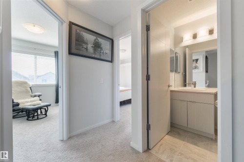 White vanity with a neutral countertop, undermount sink, and chrome faucet - 8265 Chappelle Way Sw, Edmonton, AB - Indoor