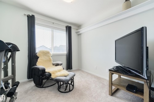 Wall-to-wall carpeting, window with blinds and drapes, and a built-in wall shelf - 8265 Chappelle Way Sw, Edmonton, AB - Indoor Photo Showing Gym Room