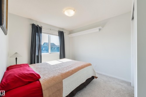 Carpeted room with a window, ceiling light fixture, and wall shelving - 8265 Chappelle Way Sw, Edmonton, AB - Indoor Photo Showing Bedroom