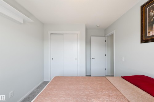 Recessed ceiling lighting, white sliding closet doors, white interior door with brushed nickel hardware, and light gray wall paint - 8265 Chappelle Way Sw, Edmonton, AB - Indoor Photo Showing Bedroom