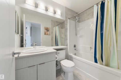 Vanity with an integrated sink, broad mirror, and a four-light fixture - 8265 Chappelle Way Sw, Edmonton, AB - Indoor Photo Showing Bathroom