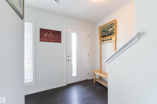 Entryway featuring dark wood-finish flooring, a white paneled door with an integrated sidelight, and a white handrail - 8265 Chappelle Way Sw, Edmonton, AB - Indoor Photo Showing Other Room