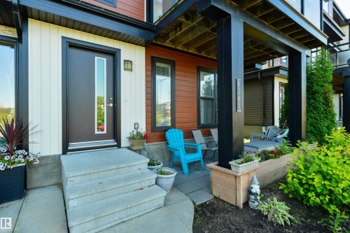 Front entry with concrete steps and a dark-paneled door featuring a full-length glass insert - 8265 Chappelle Way Sw, Edmonton, AB - Outdoor With Deck Patio Veranda With Exterior