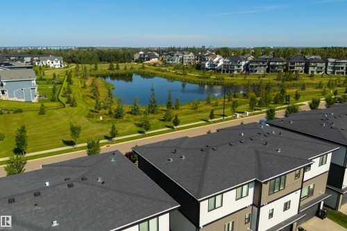 Modern residences featuring multi-level facades and dark shingle roofing - 8265 Chappelle Way Sw, Edmonton, AB - Outdoor With Body Of Water With View