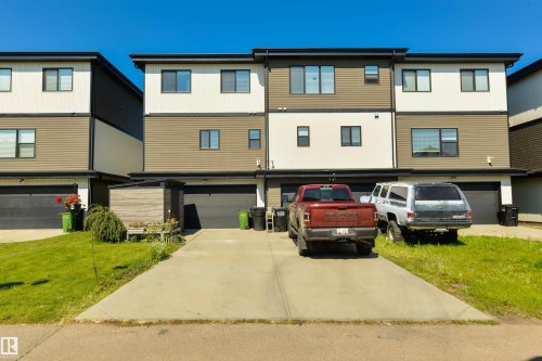 Modern multi-story exterior with horizontal siding in multiple tones, individual attached garages, and a concrete driveway - 8265 Chappelle Way Sw, Edmonton, AB - Outdoor
