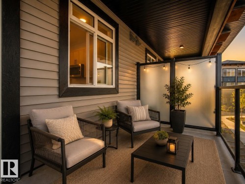 Private balcony featuring a glass railing, slat siding, and frosted privacy panels - #53 16231 19 Av Sw, Edmonton, AB - Outdoor With Exterior