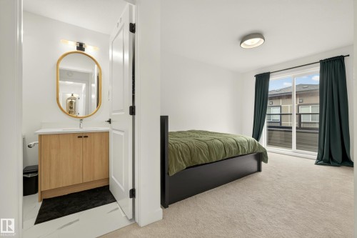 White walls, light-toned carpeting, and a sliding glass door provide brightness - #53 16231 19 Av Sw, Edmonton, AB - Indoor Photo Showing Bedroom