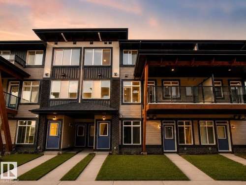 Modern exterior design featuring multiple balconies, expansive window placements, and established landscaping - #53 16231 19 Av Sw, Edmonton, AB - Outdoor With Balcony With Facade