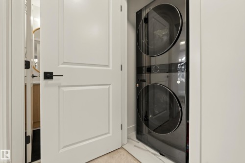 Stacked laundry system with dark finish - #53 16231 19 Av Sw, Edmonton, AB - Indoor Photo Showing Laundry Room