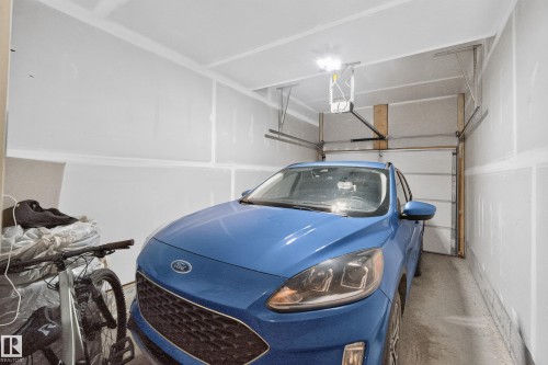 Attached automatic garage door opener with track system - #53 16231 19 Av Sw, Edmonton, AB - Indoor Photo Showing Garage