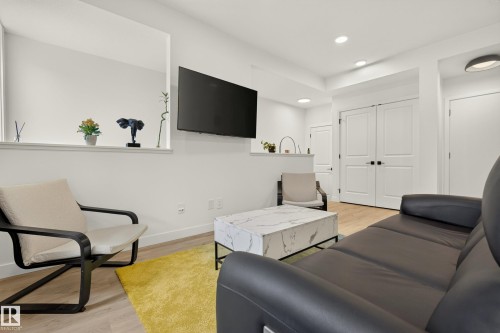 Recessed lighting, wood-finish flooring, half wall partition, and double panel doors - #53 16231 19 Av Sw, Edmonton, AB - Indoor
