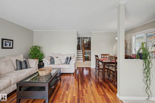 Hardwood flooring throughout, neutral paint palette, cased opening to dining area, and crown molding accents - 193 Kiniski Crescent Nw, Edmonton, AB - Indoor Photo Showing Living Room