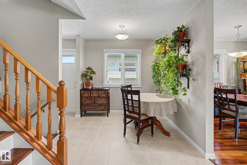 Wood staircase with balusters, tile flooring, interior lighting, and a window with blinds - 193 Kiniski Crescent Nw, Edmonton, AB - Indoor Photo Showing Other Room