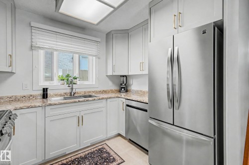 Modern kitchen featuring light gray cabinetry, stainless steel appliances, a stainless steel sink, and light-toned countertops - 193 Kiniski Crescent Nw, Edmonton, AB - Indoor Photo Showing Kitchen With Upgraded Kitchen