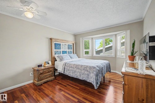 Hardwood flooring throughout, bay window with shutters, crown molding, and a ceiling fan with integrated lighting - 193 Kiniski Crescent Nw, Edmonton, AB - Indoor Photo Showing Bedroom