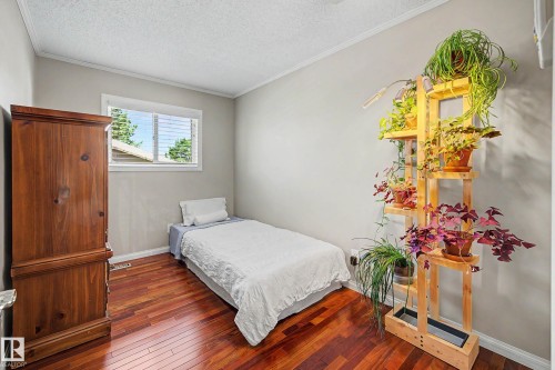 Hardwood flooring, white window trim, white wall molding, and neutral wall paint - 193 Kiniski Crescent Nw, Edmonton, AB - Indoor Photo Showing Bedroom
