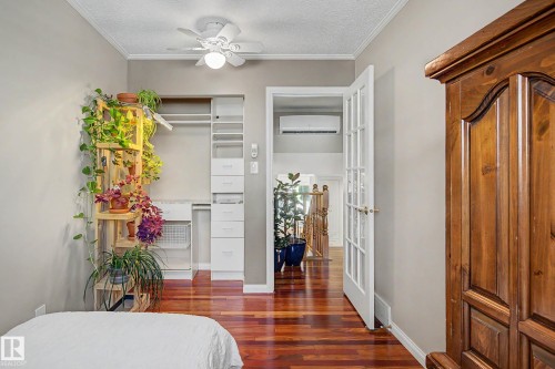 Hardwood flooring, custom closet organization system, white ceiling fan, crown molding, and French doors - 193 Kiniski Crescent Nw, Edmonton, AB - Indoor Photo Showing Other Room