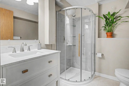 White vanity with a light-toned countertop, undermount sink, and brushed nickel faucet - 193 Kiniski Crescent Nw, Edmonton, AB - Indoor Photo Showing Bathroom