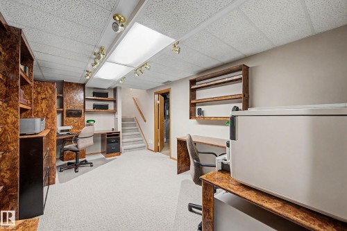 Built-in office desks with integrated shelving, overhead track lighting, and a suspended ceiling - 193 Kiniski Crescent Nw, Edmonton, AB - Indoor