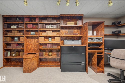 Built-in shelving units in a natural wood finish, complemented by track lighting fixtures - 193 Kiniski Crescent Nw, Edmonton, AB - Indoor Photo Showing Office
