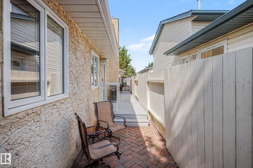Exterior wall with stucco finish, white frame windows, and an outdoor light fixture - 193 Kiniski Crescent Nw, Edmonton, AB - Outdoor With Exterior