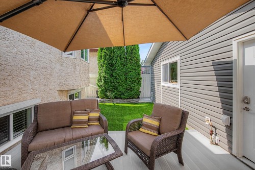 Outdoor patio featuring light-colored decking, privacy umbrella, and a manicured lawn - 193 Kiniski Crescent Nw, Edmonton, AB - Outdoor With Deck Patio Veranda With Exterior