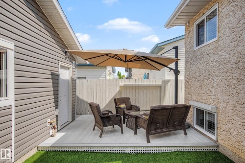 Expansive deck featuring a privacy fence, artificial turf, and a side-mounted umbrella - 193 Kiniski Crescent Nw, Edmonton, AB - Outdoor With Deck Patio Veranda With Exterior