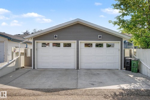 Detached garage featuring two overhead doors with window accents, gray siding, and a gabled roofline - 193 Kiniski Crescent Nw, Edmonton, AB - Outdoor With Exterior