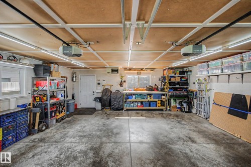 Concrete flooring, built-in shelving, two automatic garage door openers, overhead lighting, and a utility window - 193 Kiniski Crescent Nw, Edmonton, AB - Indoor Photo Showing Garage