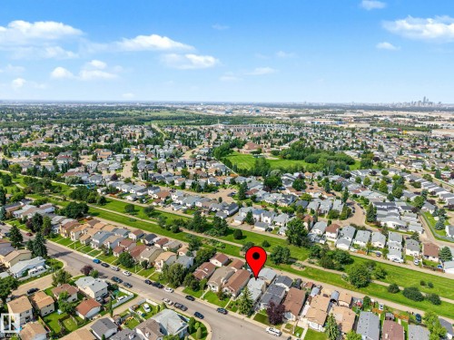 Aerial perspective showcasing the residential neighborhood with ample green spaces and distant city skyline - 193 Kiniski Crescent Nw, Edmonton, AB - Outdoor With View