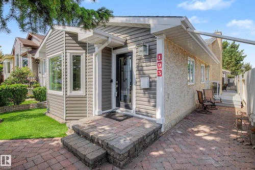 Front entry featuring a paver stone walkway, mature landscaping, and an awning over the side patio - 193 Kiniski Crescent Nw, Edmonton, AB - Outdoor