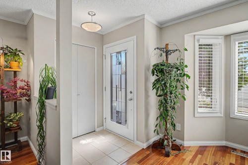 Foyer featuring tile flooring, a bay window with blinds, and a white entry door with decorative glass inserts - 193 Kiniski Crescent Nw, Edmonton, AB - Indoor Photo Showing Other Room