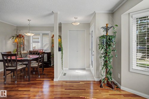 Wood-finish flooring throughout, white trim, and a built-in closet with bi-fold doors - 193 Kiniski Crescent Nw, Edmonton, AB - Indoor