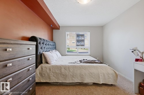 Window with exterior building visibility, wall-to-wall carpeting, and neutral paint - #106 13907 136 St Nw, Edmonton, AB - Indoor Photo Showing Bedroom