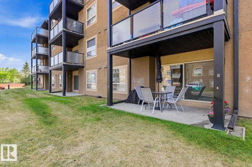 Ground-level patio with a concrete surface, covered by an upper-level balcony - #106 13907 136 St Nw, Edmonton, AB - Outdoor