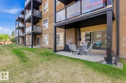 Ground-level patio with a concrete surface, covered by an upper-level balcony - 