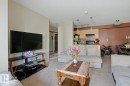 Open-concept living area with neutral carpeting, recessed lighting, and a kitchen featuring wood-finish cabinetry - #106 13907 136 St Nw, Edmonton, AB  - Indoor Photo Showing Living Room 