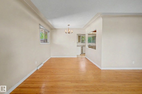 Hardwood flooring throughout, recessed ceiling, and a traditional chandelier - 9723 76 Street Nw, Edmonton, AB - Indoor Photo Showing Other Room