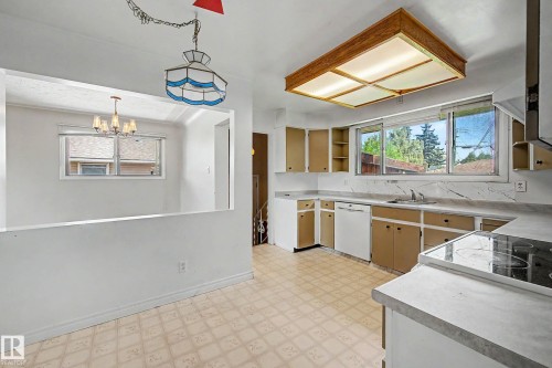 Kitchen with L-shaped counter space, built-in cooktop, and window overlooking exterior - 9723 76 Street Nw, Edmonton, AB - Indoor Photo Showing Kitchen