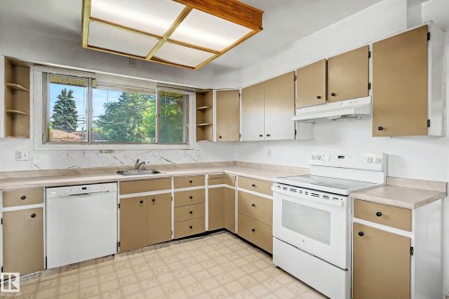 Kitchen featuring a built-in dishwasher, white electric range, and ample cabinetry with contrasting finishes - 9723 76 Street Nw, Edmonton, AB - Indoor Photo Showing Kitchen